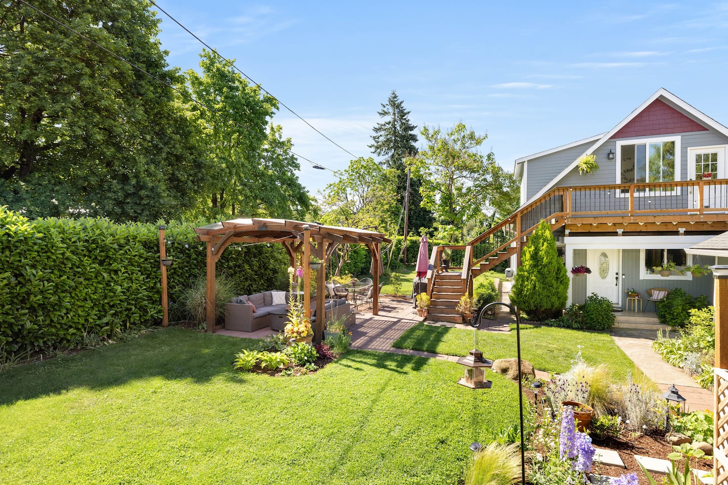 Laurel House seen from the garden, with the pergola, lawn and wooden staircase